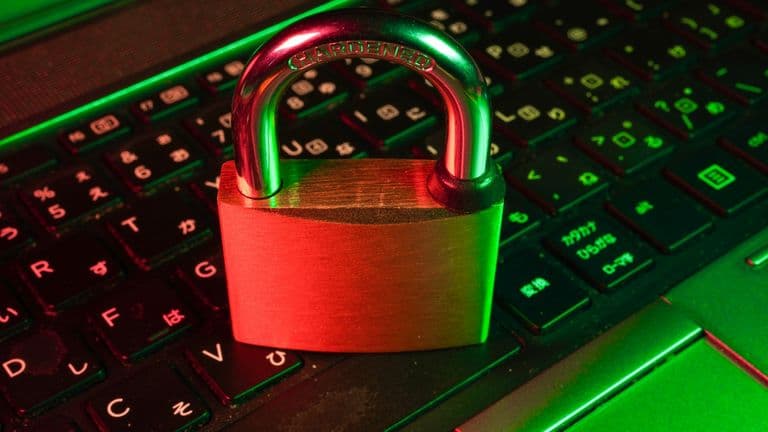 Red padlock resting on a black computer keyboard